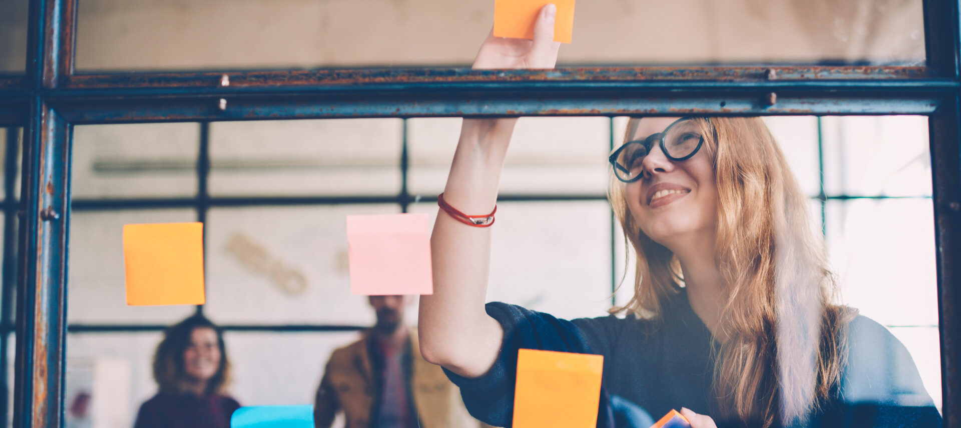 Woman placing post-it notes on a window