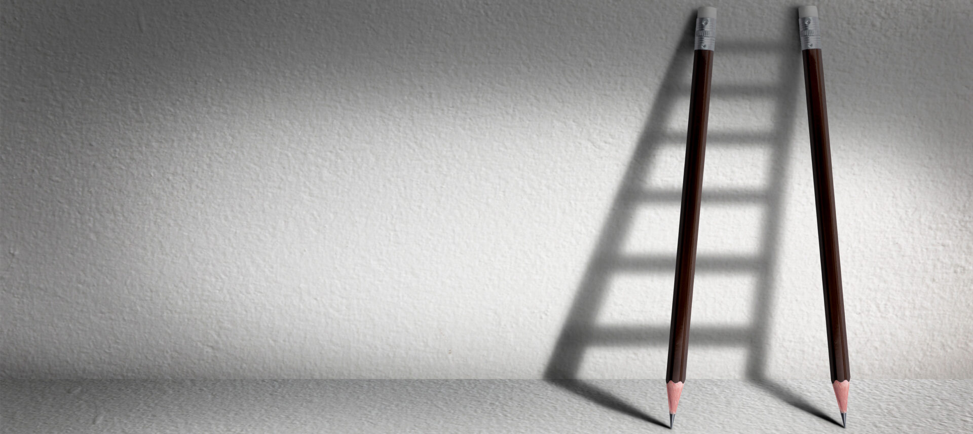 2 pencils against a wall throwing a ladder shadow