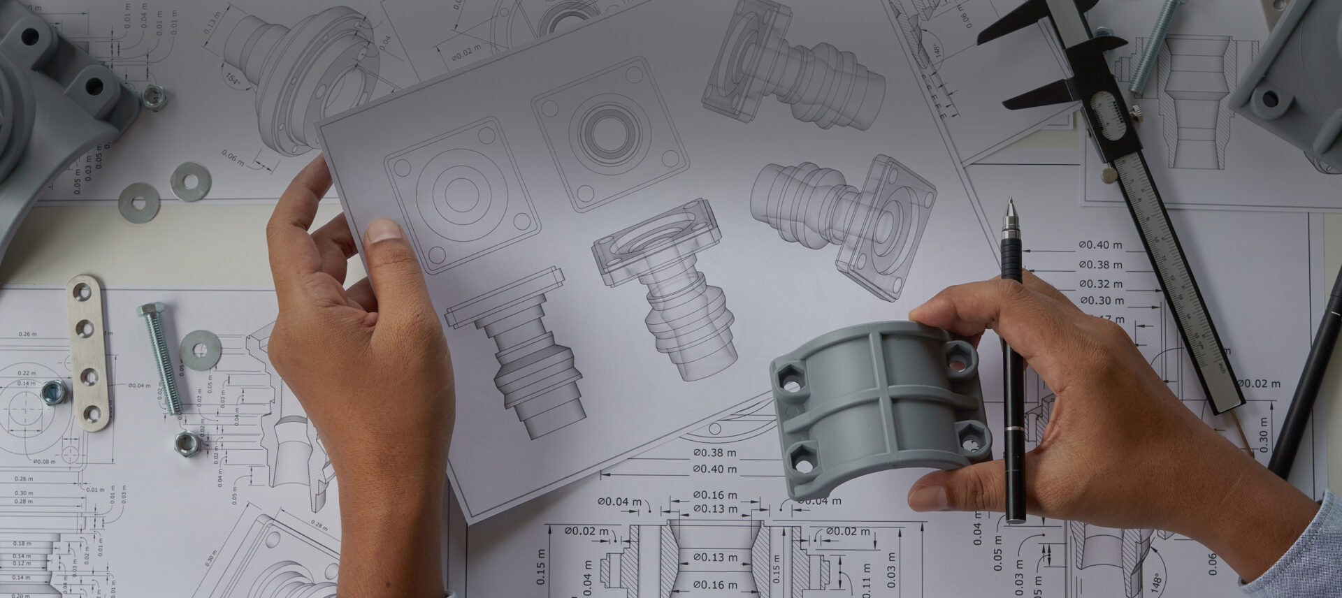 engineer holding a part next to an engineering drawing