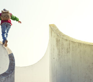 man walking on the edge of a concrete wall